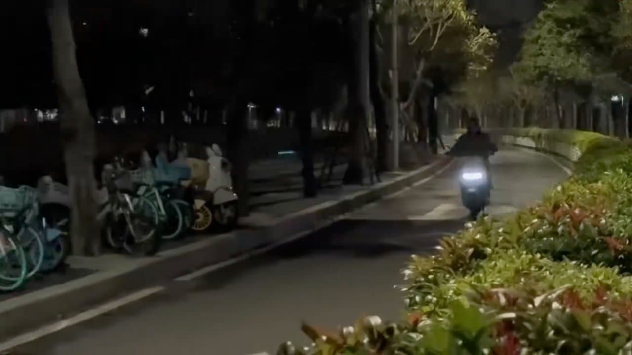 A still from the night-time scooter clip, showing Yuzhe approaching the camera.